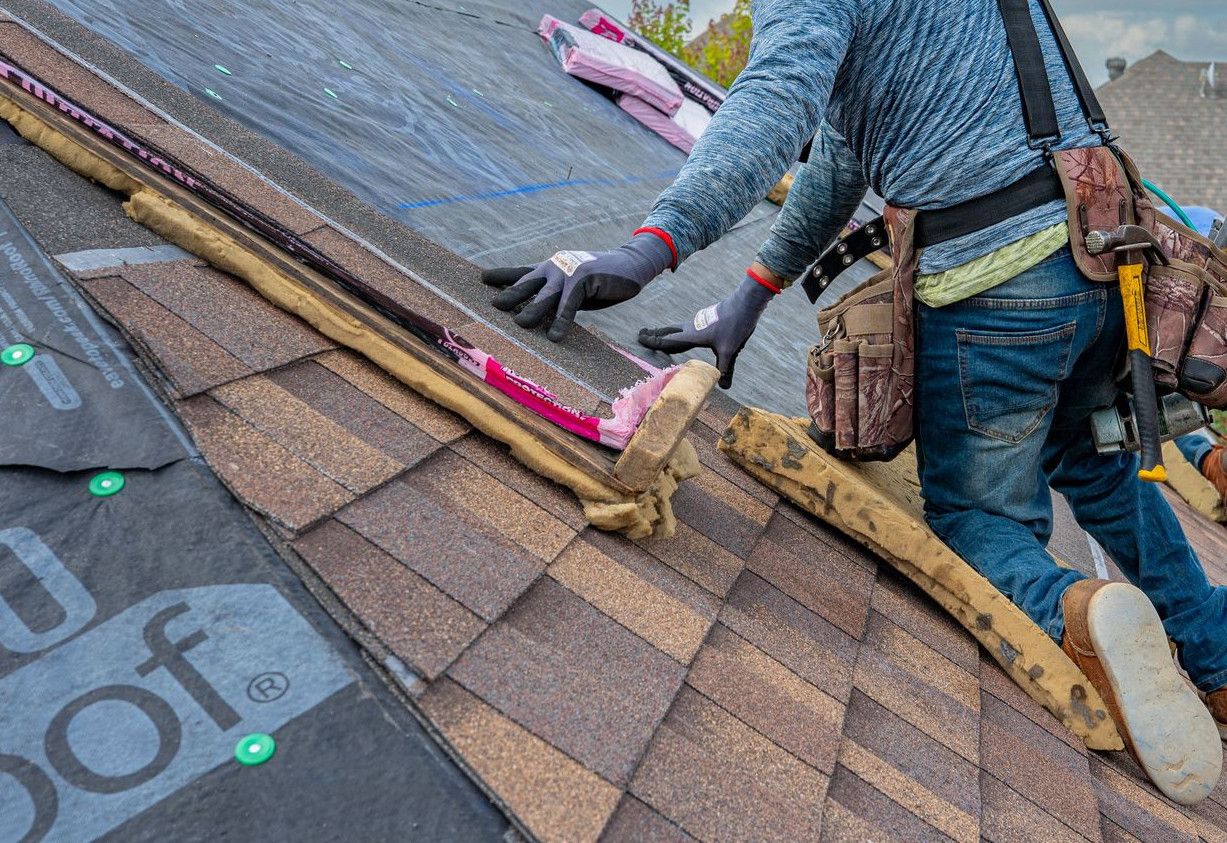 Roofers working on shingle installation on a home in Fort Worth, Texas under blue skies.