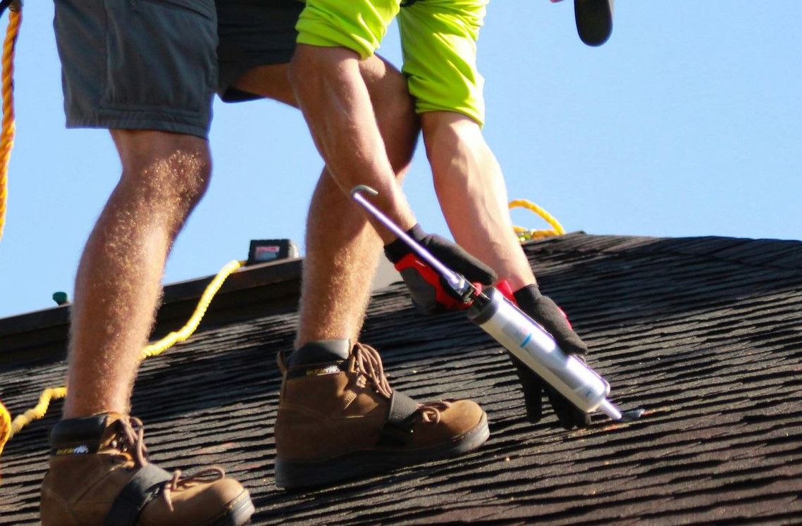 a man in a yellow shirt is working on a roof