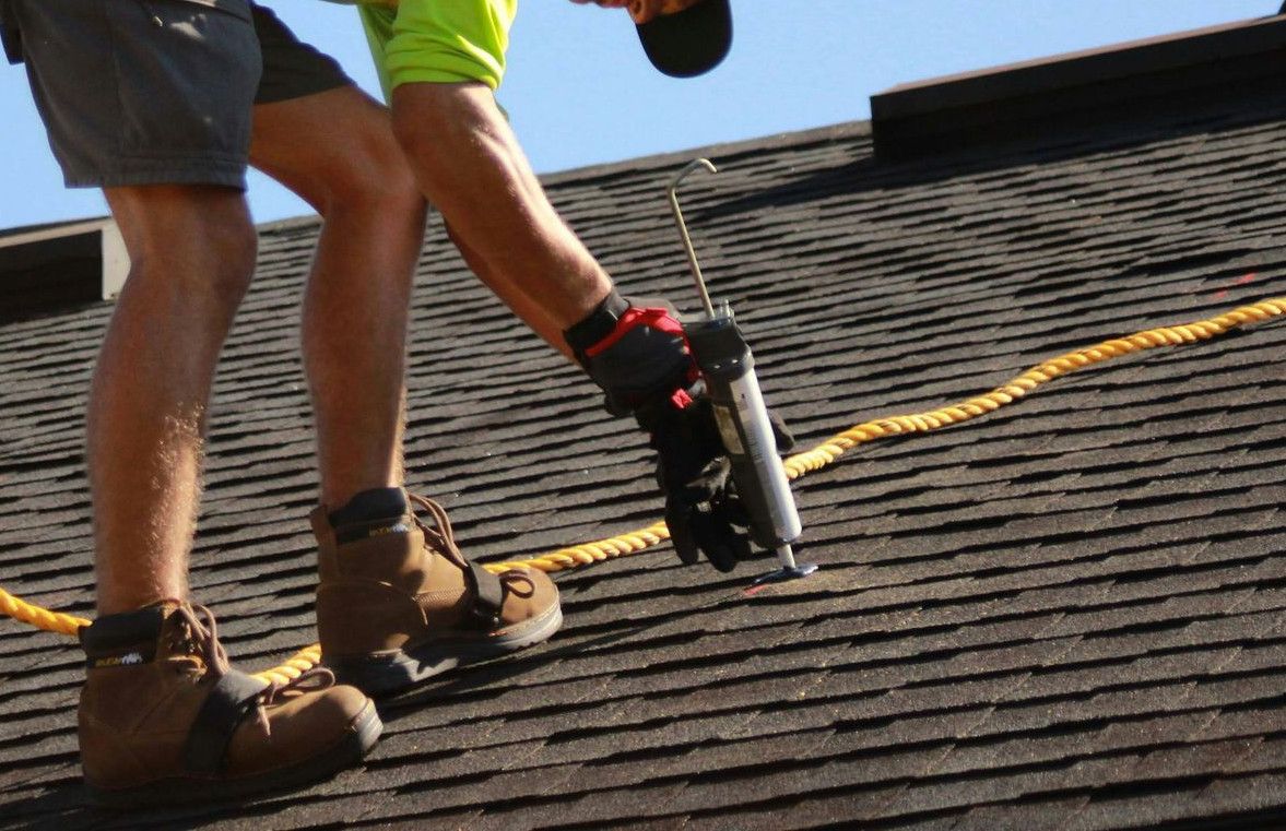 a man working on a roof with a power drill