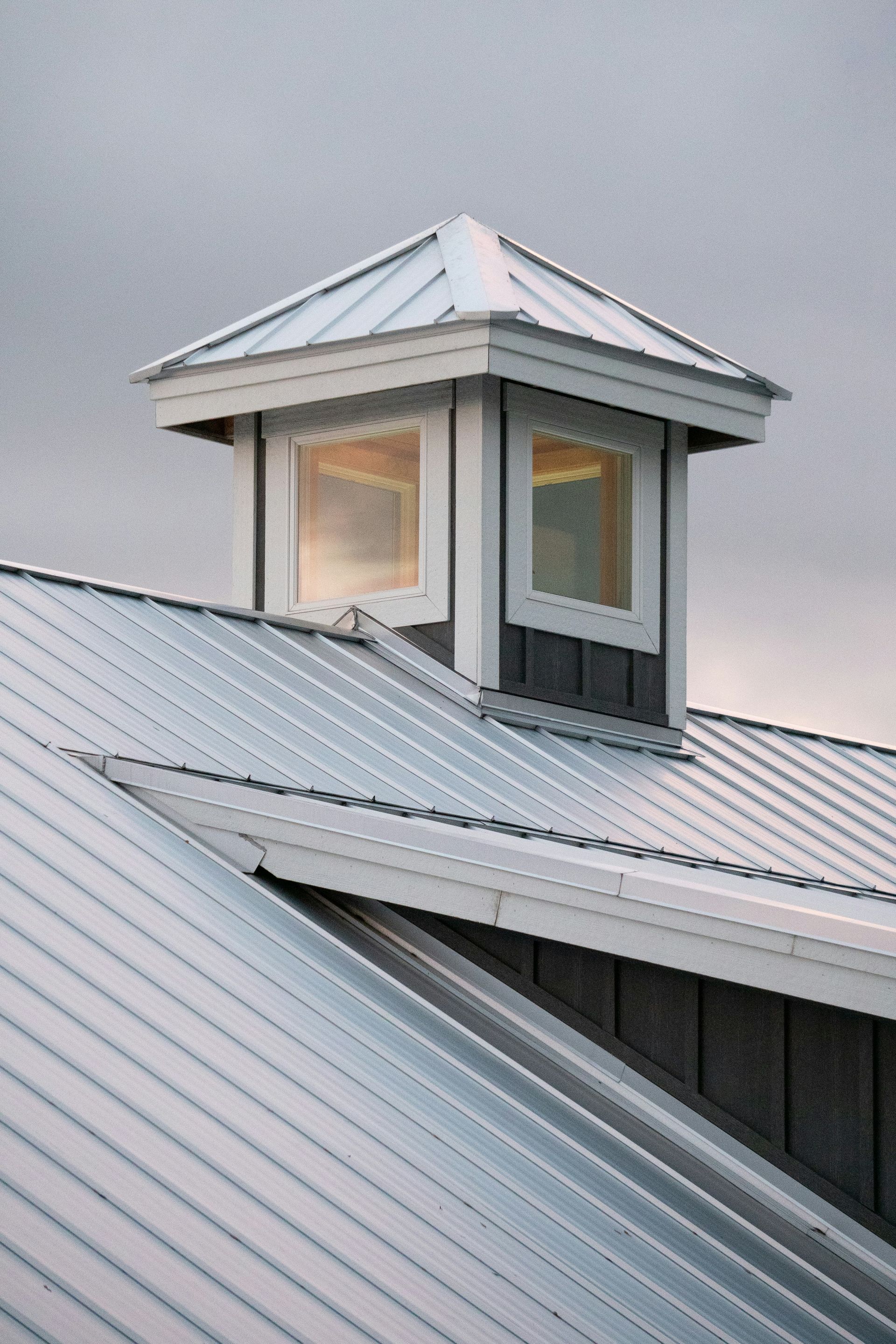 Modern barn roof with cupola and cloudy sky